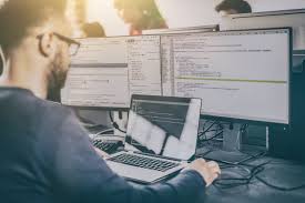 Profesional de finanzas ante pantallas de datos y análisis financiero